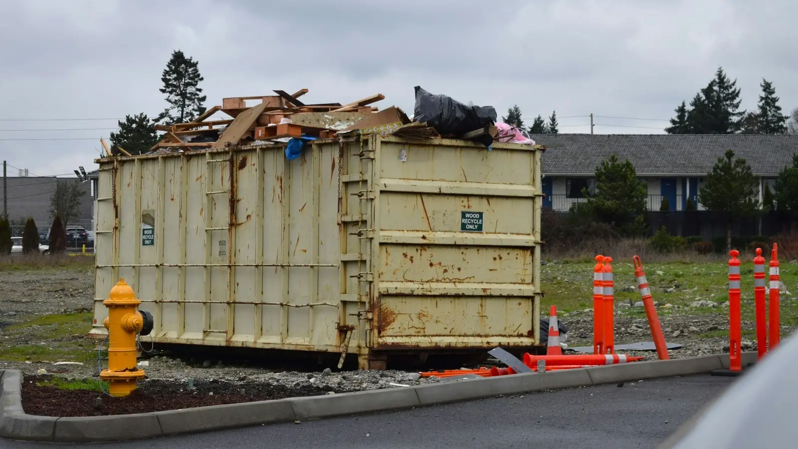 Roll-off dumpster loaded with construction debris on a residential street